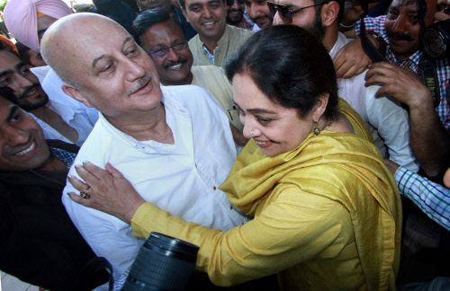 Bollywood actor Anupam Kher and his wife BJP candidate Kirron Kher hug each other during election campaign in Chandigarh on Thursday. PTI Photo
