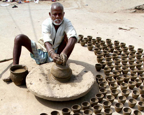 A potter makes small earthen pots on International Labor Day, on the outskirts of Ajmer on Sunday. PTI Photo