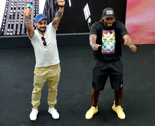  RCB Skipper Virat Kohli with teamate Chris Gayle during an event at a mall in Bengaluru on Sunday. PTI Photo