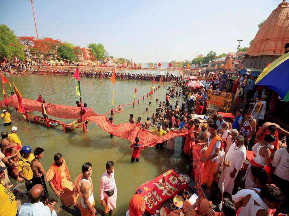 Swami Avimukteshwaranand Saraswati and Sadhus or holy men offering chunari to Maa Kshipra during Shimhasth Kumbha Mela in Ujjain on Friday. PTI Photo.