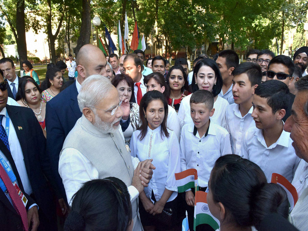 Prime Minister Narendra Modi interacts with Indian community children after paying floral tributes to former Prime Minister Lal Bahadur Shastri at Shastri street in Tashkent on Friday. PTI Photo
