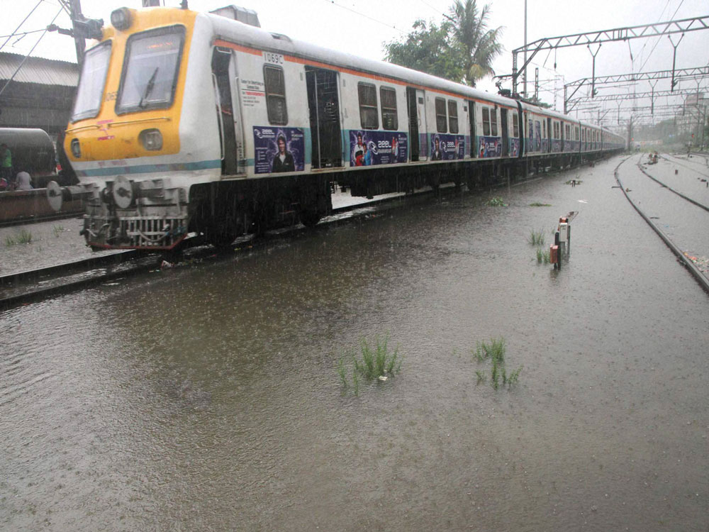  Local train on water logged railway track in Thane on Saturday. Local train services were disrupted by one hour after heavy rainfall. PTI Photo