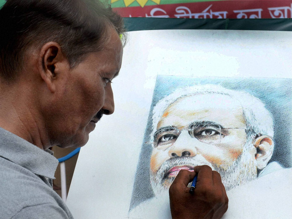 Renowned painter Partha Das gives final touch to a potrait of Prime Minister Narendra Modi on the eve of Modi's birthday at BJP state party office in Kolkata on Friday. PTI Photo