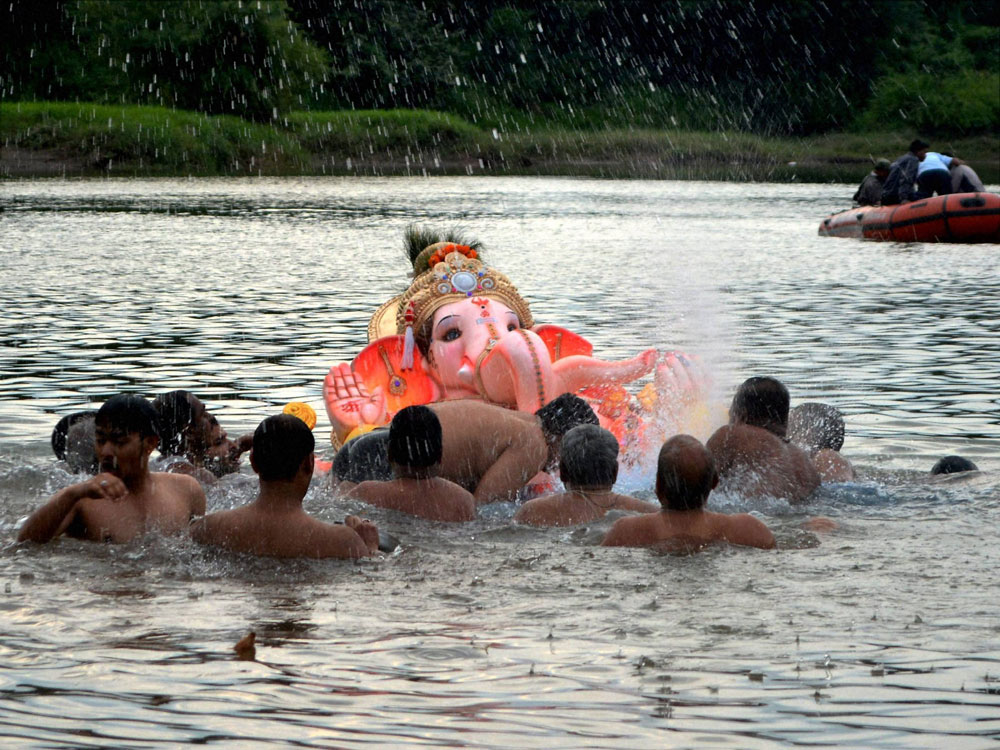  Devotees immersing a Lord Ganesha idol in a water tank during last day of Ganesh festival in Karad, Maharashtra on Thursday. PTI Photo