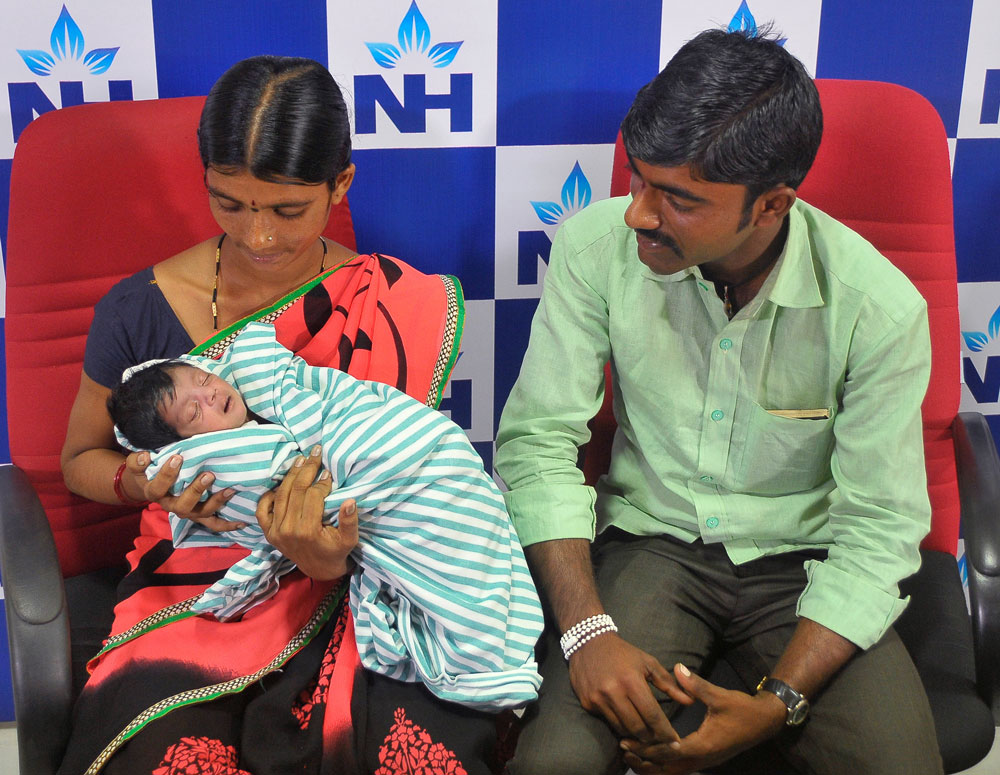 Lalithamma (L) holds her baby, who was born with four legs and two sets of genitals according to doctors, as her husband looks on during a news conference after a successful operation, in Bengaluru, India February 9, 2017. REUTERS