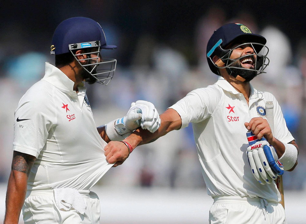 India's captain Virat Kohli pulls the shirt of teammate Murali Vijay as they leave the ground for tea break during the first day of the test match against Bangladesh in Hyderabad on Thursday. PTI Photo