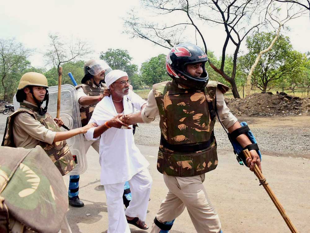 Police detain of farmers who were pelting stones during their agitation in Phanda near Bhopal on Friday.
