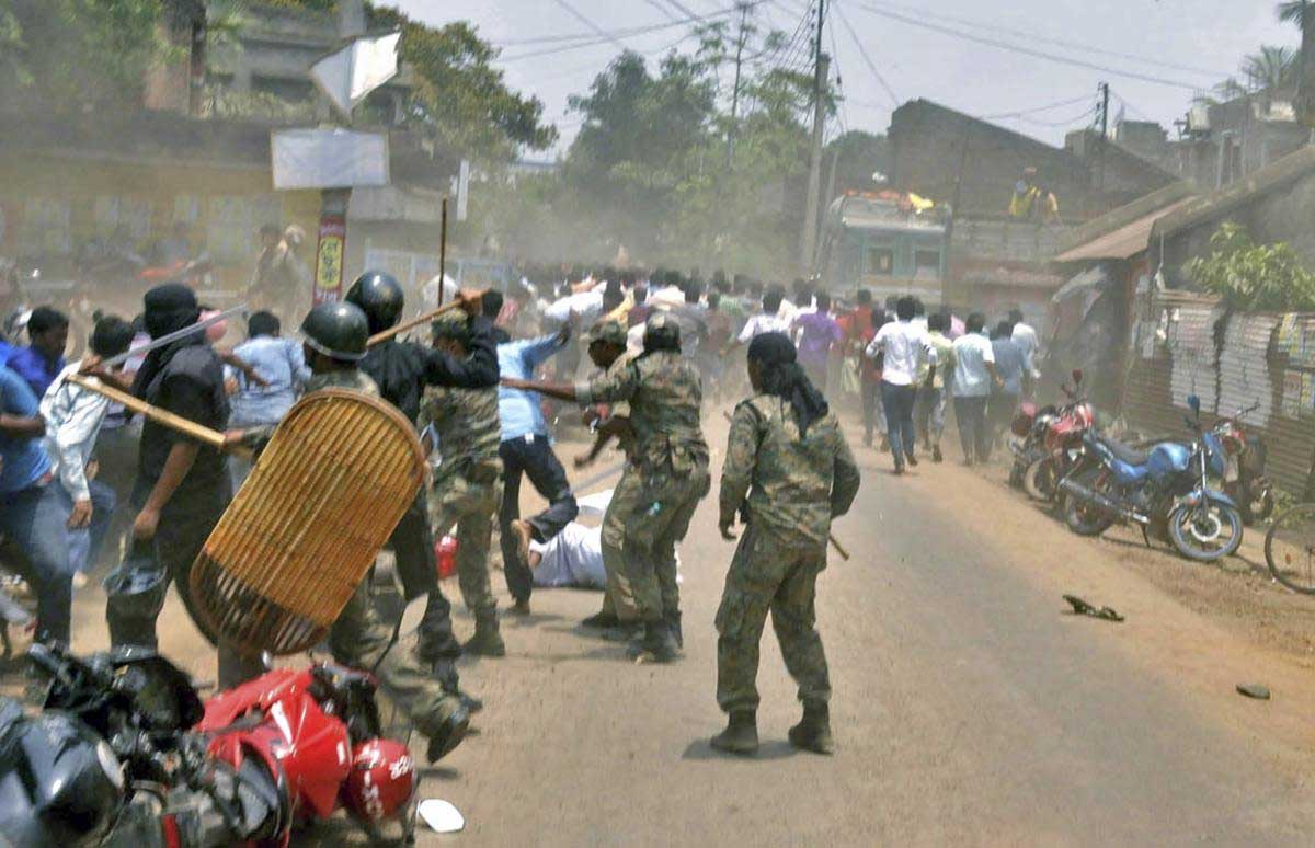 Security personnel try to disperse a mob after clashes between BJP and TMC activists during the counting of votes for Panchayat polls, at Mallarpur in Birbhum district of West Bengal, on Thursday. PTI Photo