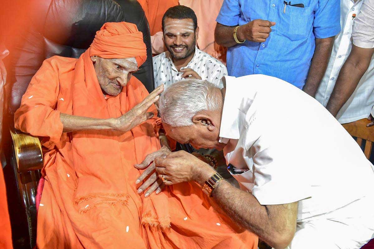 Newly-elected Karnataka chief minister BS Yeddyurappa seeks the blessings of Shivakumara Swami, at Sree Siddaganga Matha in Tumkur, on Thursday. PTI Photo