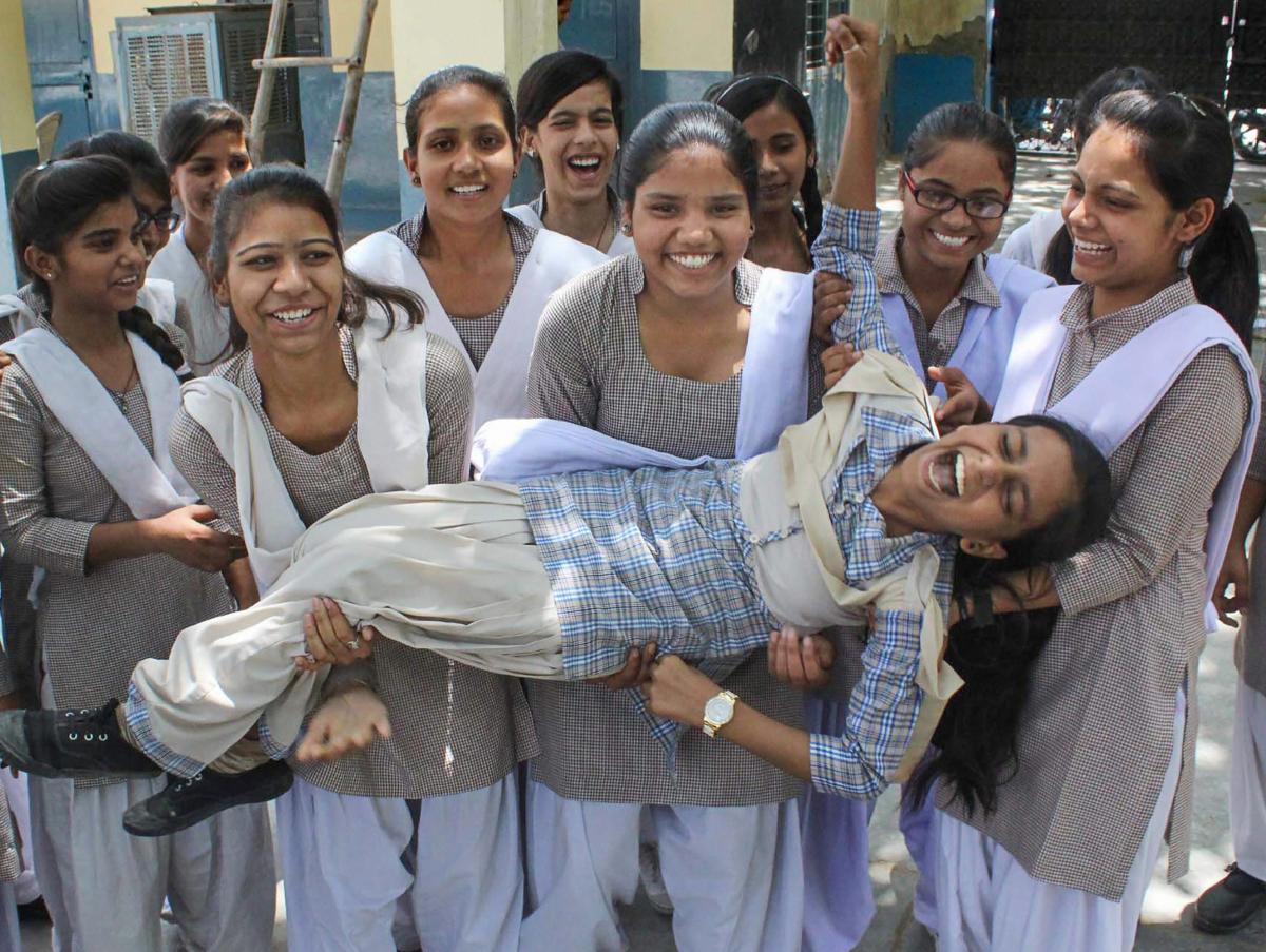 Students pose for a photograph as they celebrate after the announcement of Haryana Board class 10th results, in Gurugram. PTI Photo