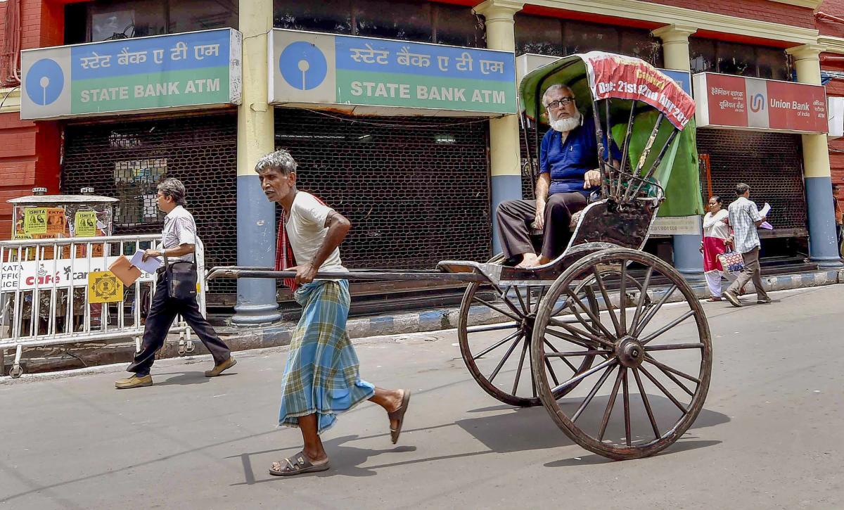 A hand rickshaw puller walks past a closed bank ATM on the second day of the two-day nationwide strike called by the United Forum of Bank Unions (UFBU) to press for wage revision, in Kolkata, Thursday, May 31, 2018. (PTI Photo/Ashok Bhaumik)