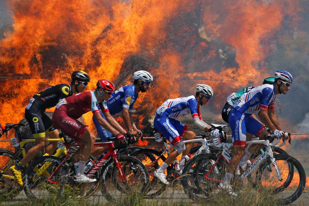 our de France - The 181-km Stage 6 from Brest to Mur-de-Bretagne Guerleden - July 12, 2018 - The peloton passes a fire. REUTERS