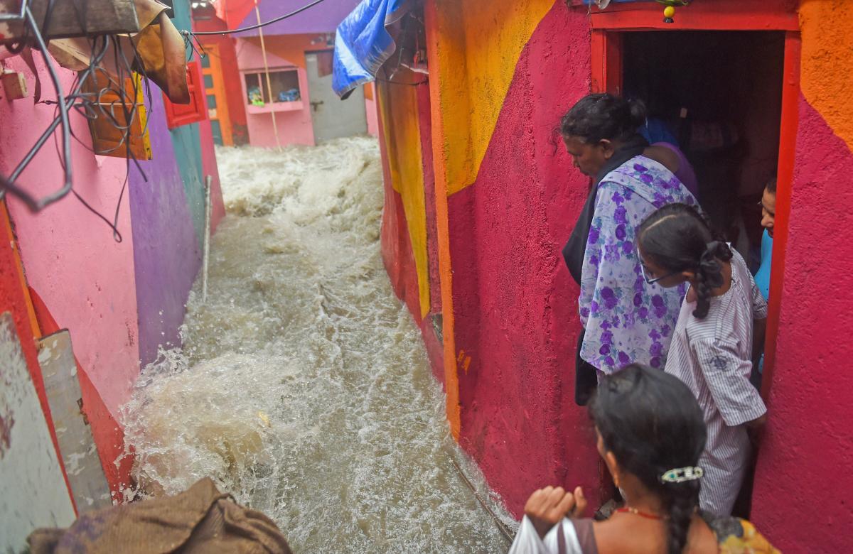 People watch a high tide sea wave entering the shanty town near the shore, at Bandra in Mumbai on Saturday, July 14, 2018. (PTI Photo/Shashank Parade)