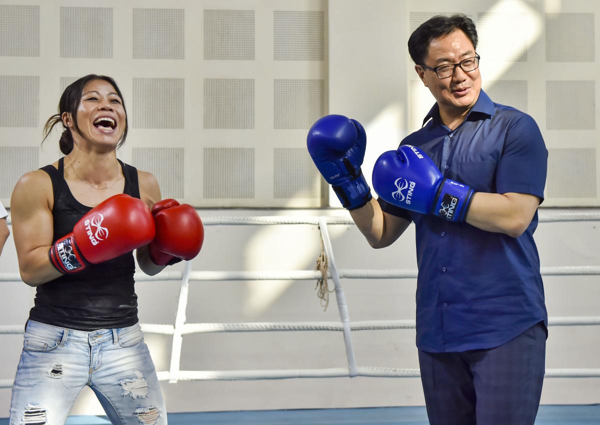 Minister Kiren Rijiju poses with World Champion boxer Mary Kom for photographs at Indira Gandhi Stadium in New Delhi. (PTI Photo)
