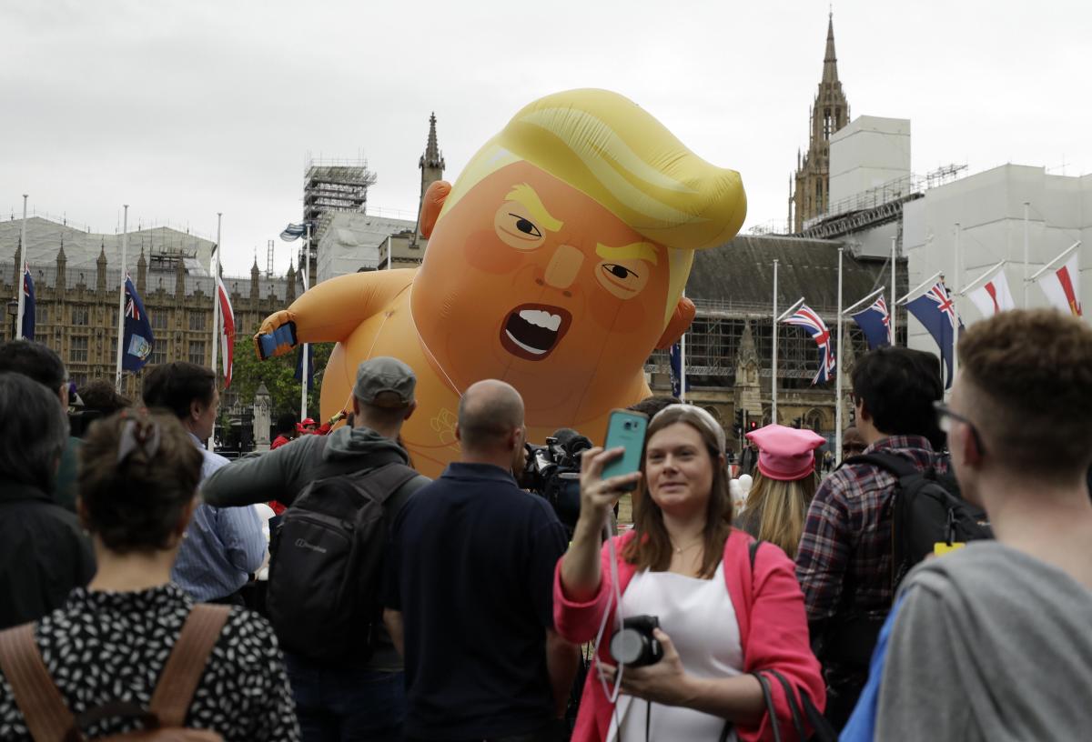 A woman takes a selfie as the 'Trump Baby' blimp is inflated in Parliament Square in central London as people start to gather to demonstrate against the state visit of President Donald Trump. (AP/PTI Photo)
