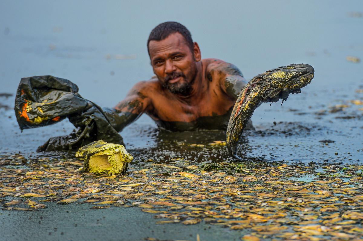 A man shows fish that are believed to have died in the drying Lake Thiruneermalai due to lack of rainfall, in Chennai, Friday, June 7, 2019. (PTI Photo/R Senthil Kumar)