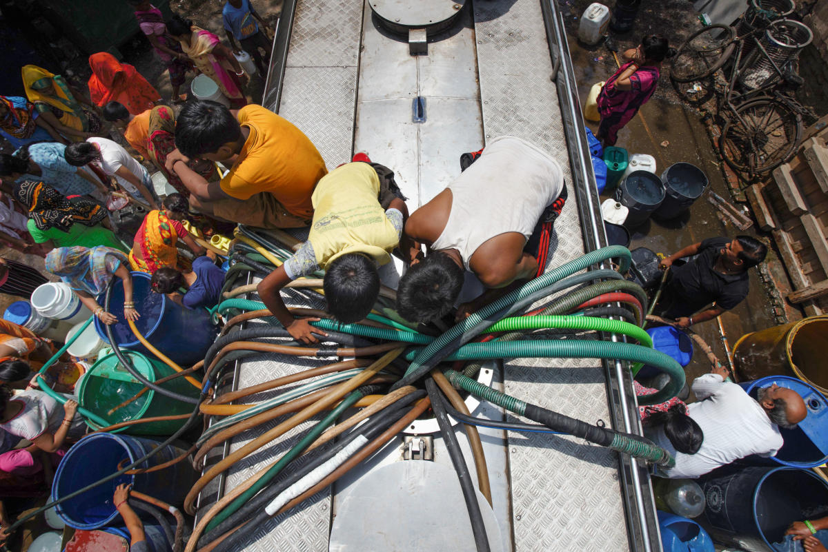 Residents collect water from a New Delhi Municipal Council (NDMC) tanker, in Chanakyapuri, New Delhi, Friday, June 7, 2019. (PTI Photo/Shashwat Das)