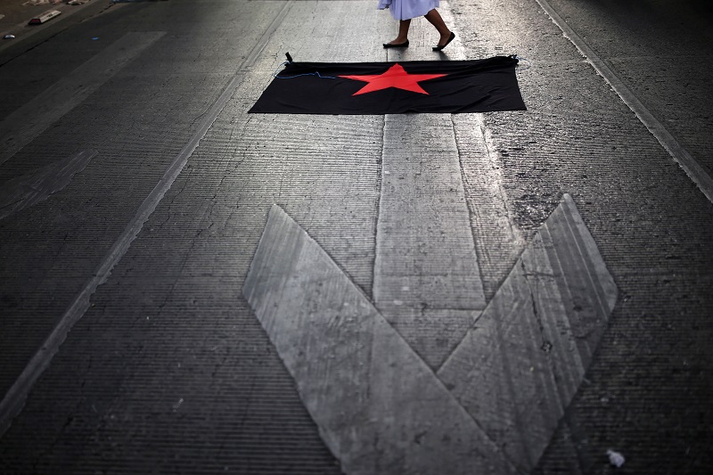 A woman participates in a march to mark the 65th month since the disappearance of the 43 missing Ayotzinapa College Raul Isidro Burgos students in the state of Guerrero, in Mexico City. (Reuters Photo)