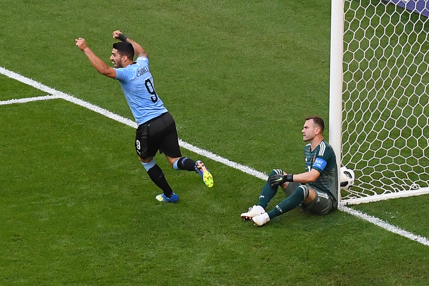 Uruguay's forward Luis Suarez (L) celebrates and Russia's goalkeeper Igor Akinfeev (R) reacts after Uruguay's second goal scored by Uruguay's defender Diego Laxalt during the Russia 2018 World Cup Group A football match between Uruguay and Russia at the Samara Arena in Samara on June 25, 2018. Source: MANAN VATSYAYANA / AFP