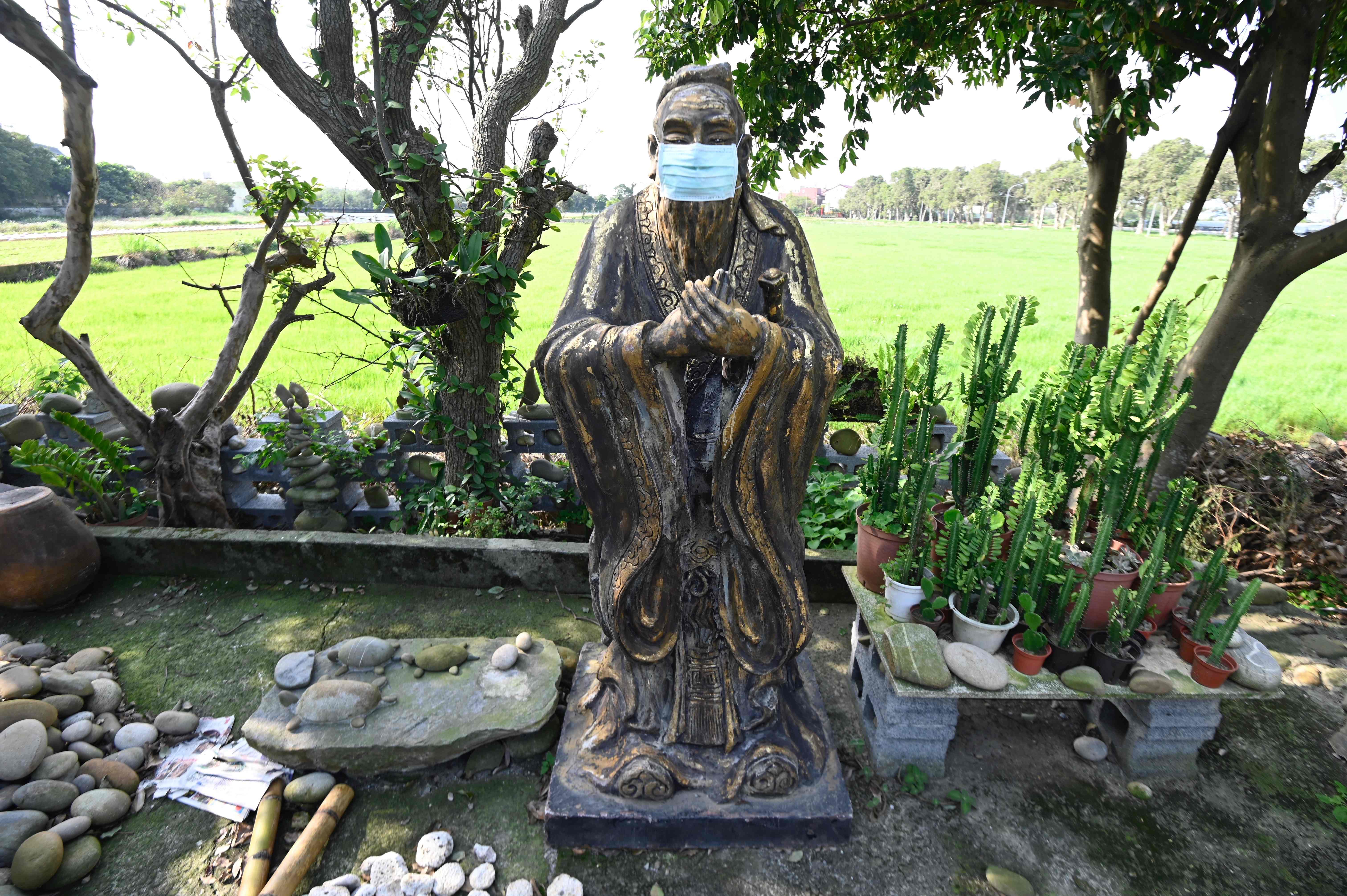 This picture shows a masked Chinese prophet Confucius statue, part of a collection by Taiwan’s sculptor Lin Hsin-lai, in Taoyuan, northern Taiwan. (Credit: AFP)