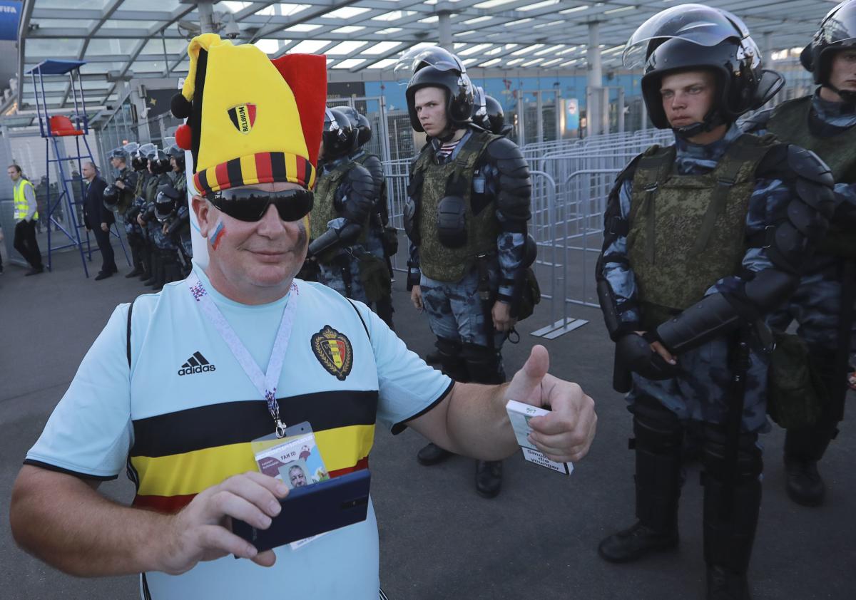 A supporter of Belgium poses for a picture as riot policemen stand guard after the match. Reuters  Photo