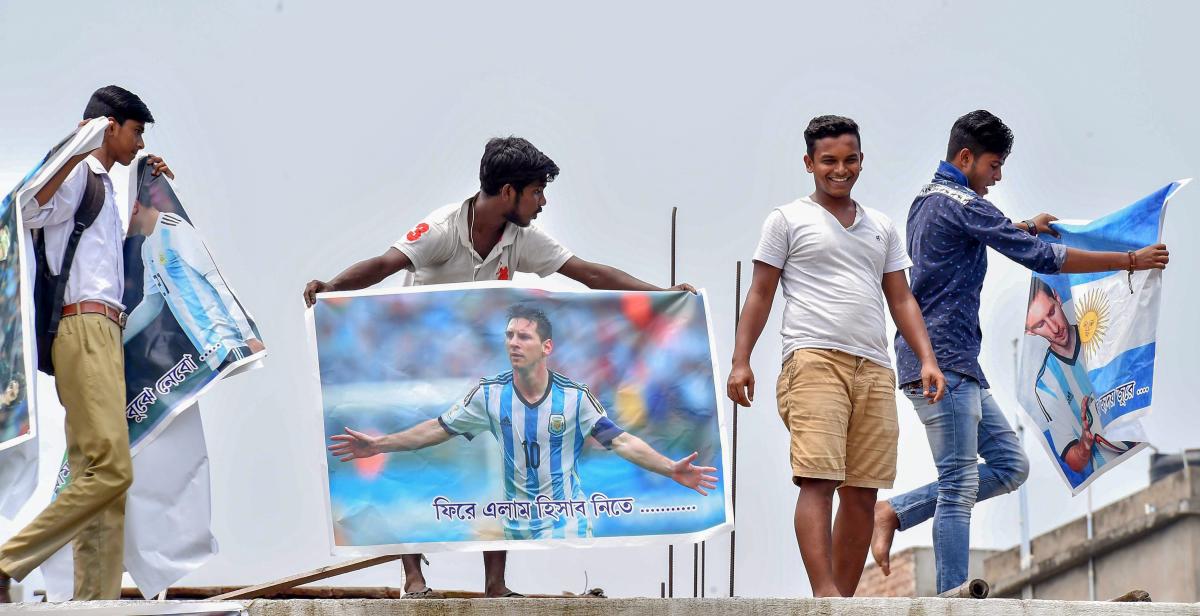 Enthusiastic soccer fans hang the poster of Argentinian footballer Lionel Messi on a roof of a club ahead of the FIFA World Cup 2018, in Kolkata on Tuesday. PTI Photo
