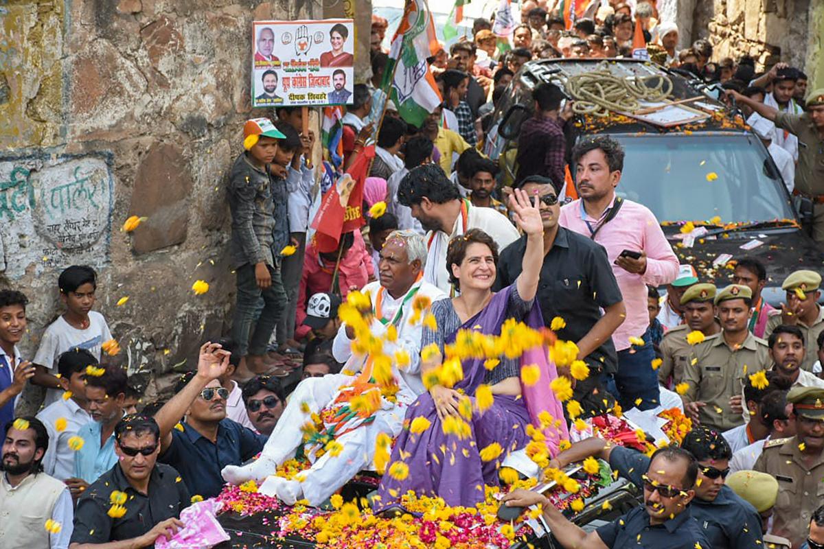 Congress General Secretary Priyanka Gandhi Vadra waves at the supporters during an election campaign roadshow in support of the party candidate Shiv Sharan Kushwaha(to Priyanka's right) for the Lok Sabha elections, in Jhansi, Thursday, April 25, 2019. (PTI Photo)