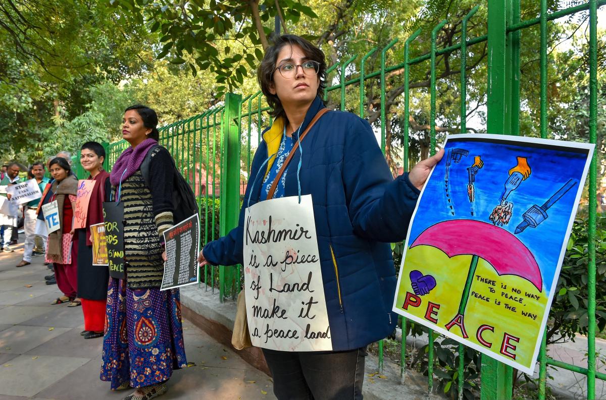 People hold placards as they form a human chain against unilateral air strikes by India and Pakistan following the Pulwama terror attack, in New Delhi. PTI