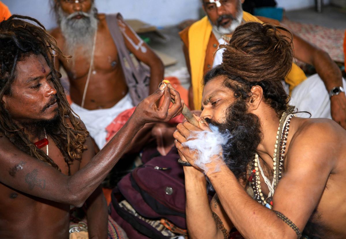 Sadhus smoke marijuana as they wait to register themselves for the Amarnath Yatra, at Ram Mandir base camp in Jammu on Saturday.  PTI Photo