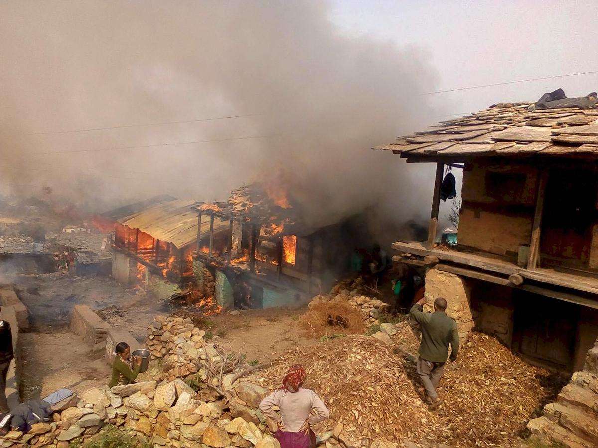 Villagers look on as a major fire breaks out, at Kanyal village of Uttarkashi district, on Friday.  PTI Photo