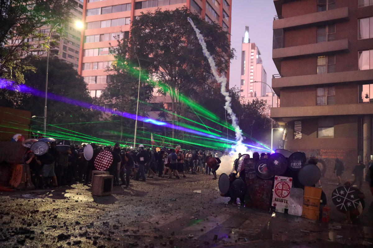 Laser beams shine through a crowd of demonstrators clashing with police during a protest against Chile's government in Santiago, Chile March 6, 2020. REUTERS/Pablo Sanhueza