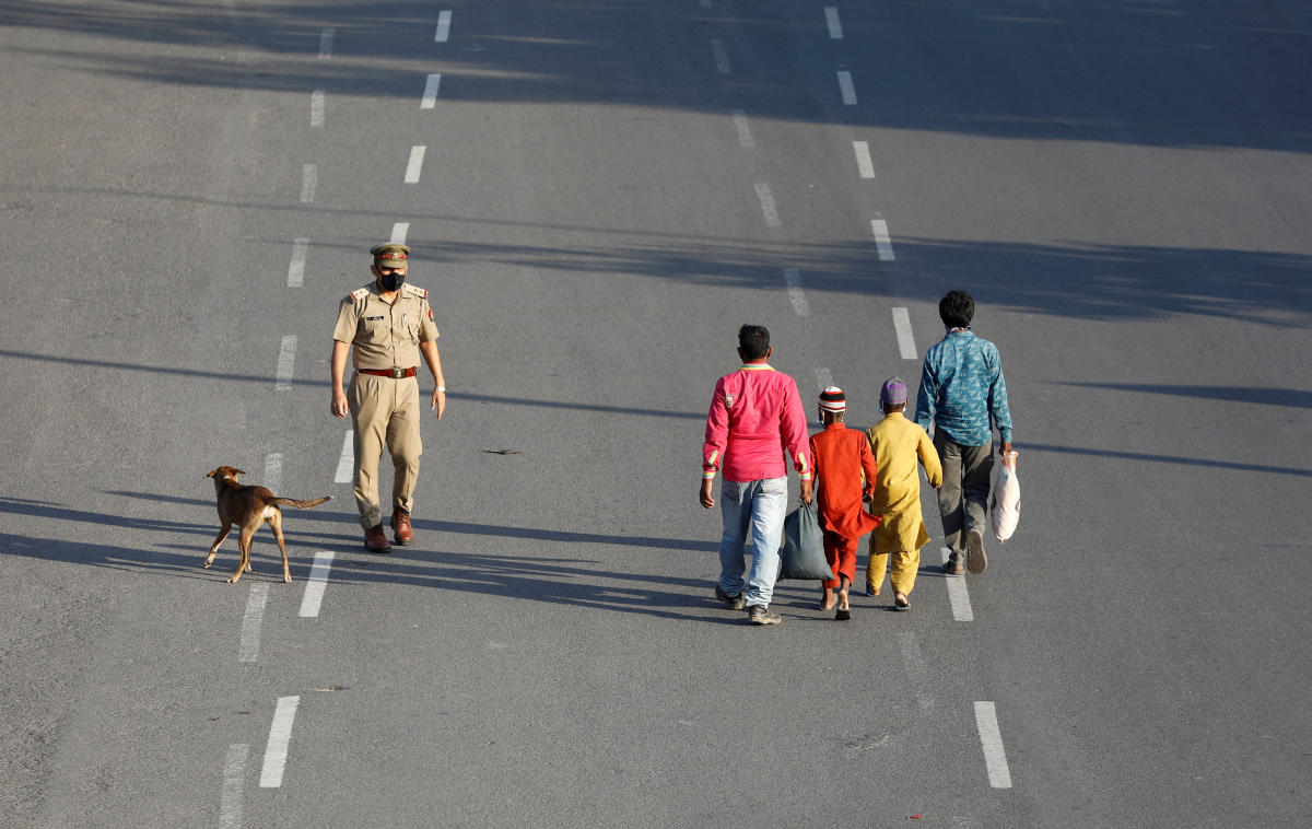 Migrant workers and their families walk to board a bus to reach a railway station to drive to their home state of eastern Bihar, after a limited reopening of India's giant rail network following a nearly seven-week lockdown to slow the spreading of the coronavirus disease (COVID-19), in Noida, India, May 16, 2020. Credit: Reuters Photo