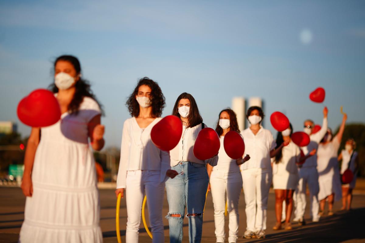 Artists perform during a protest in honor of people who died victim of the new coronavirus, COVID-19, and in defense of democracy, at the Cultural Complex of the Republic in Brasilia. Credit/AFP Photo