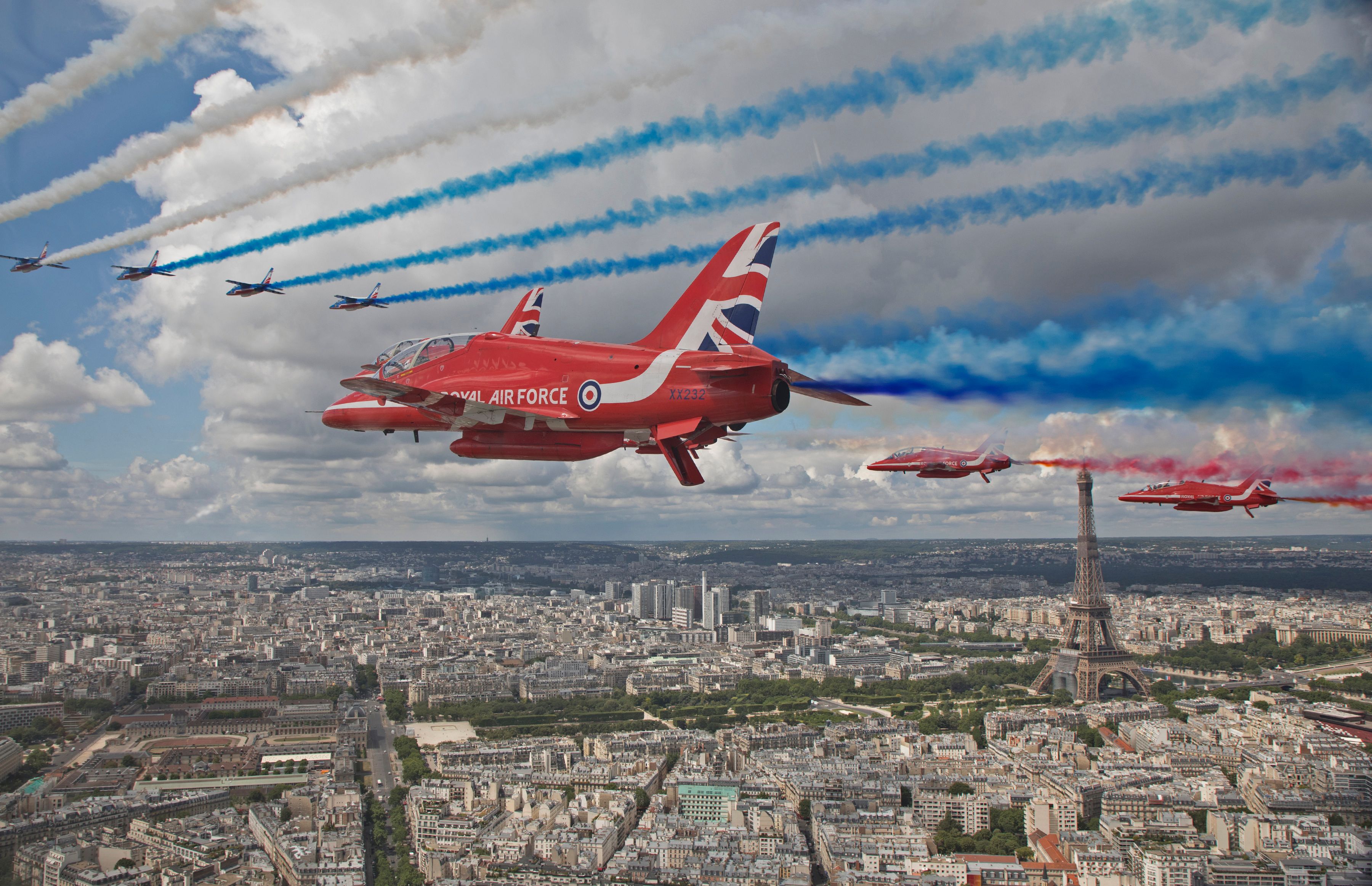 The Royal Air Force Aerobatic Team, the Red Arrows, and the French Air Force Aerobatic Team, La Patrouille de France, perform a fly-past over Paris, France. Credit: AFP Photo
