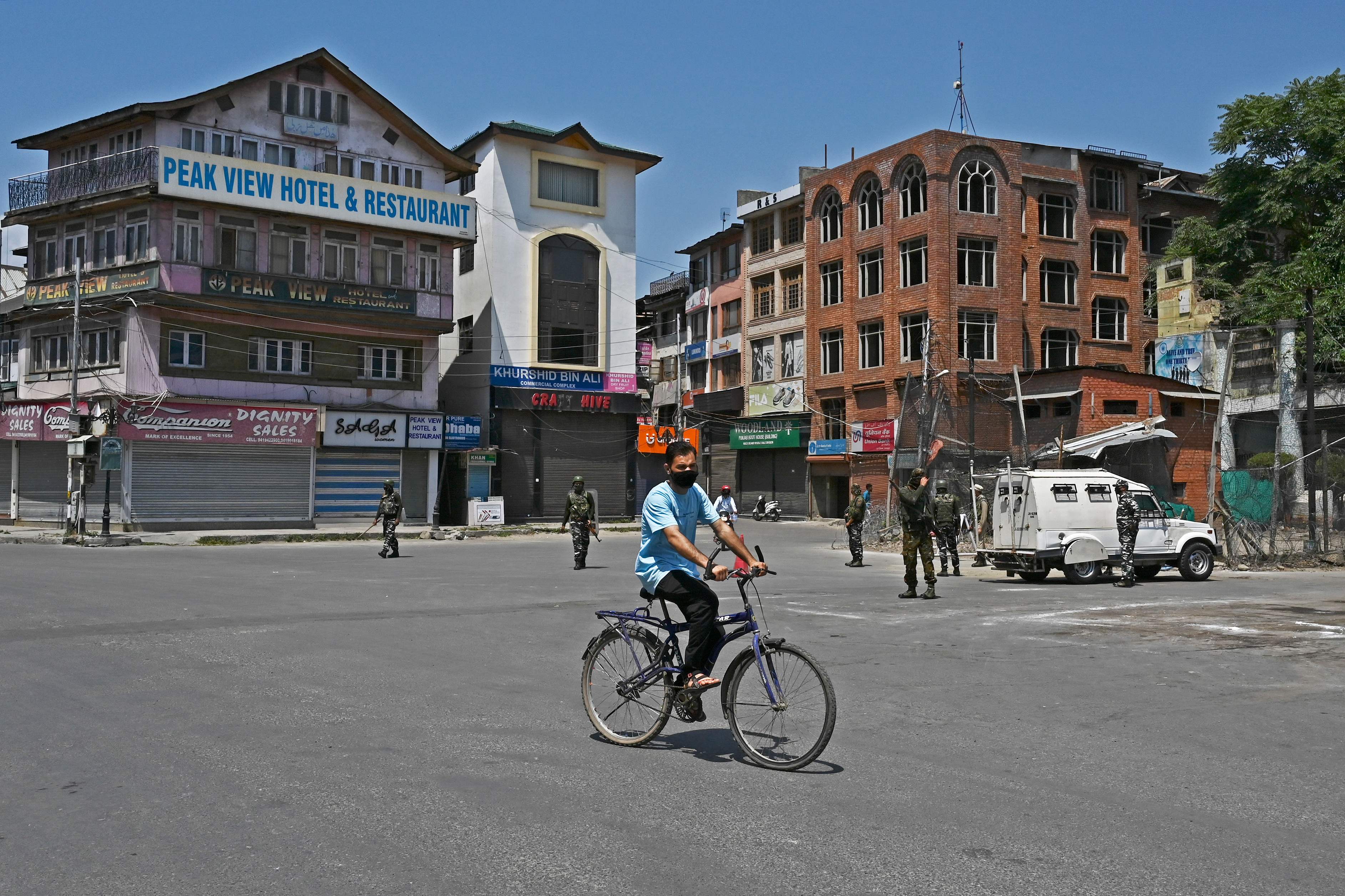 A man rides a bicycle through a road during a lockdown imposed by authorities after a sudden surge of Covid-19 coronavirus cases, in Srinagar. Credit: AFP Photo