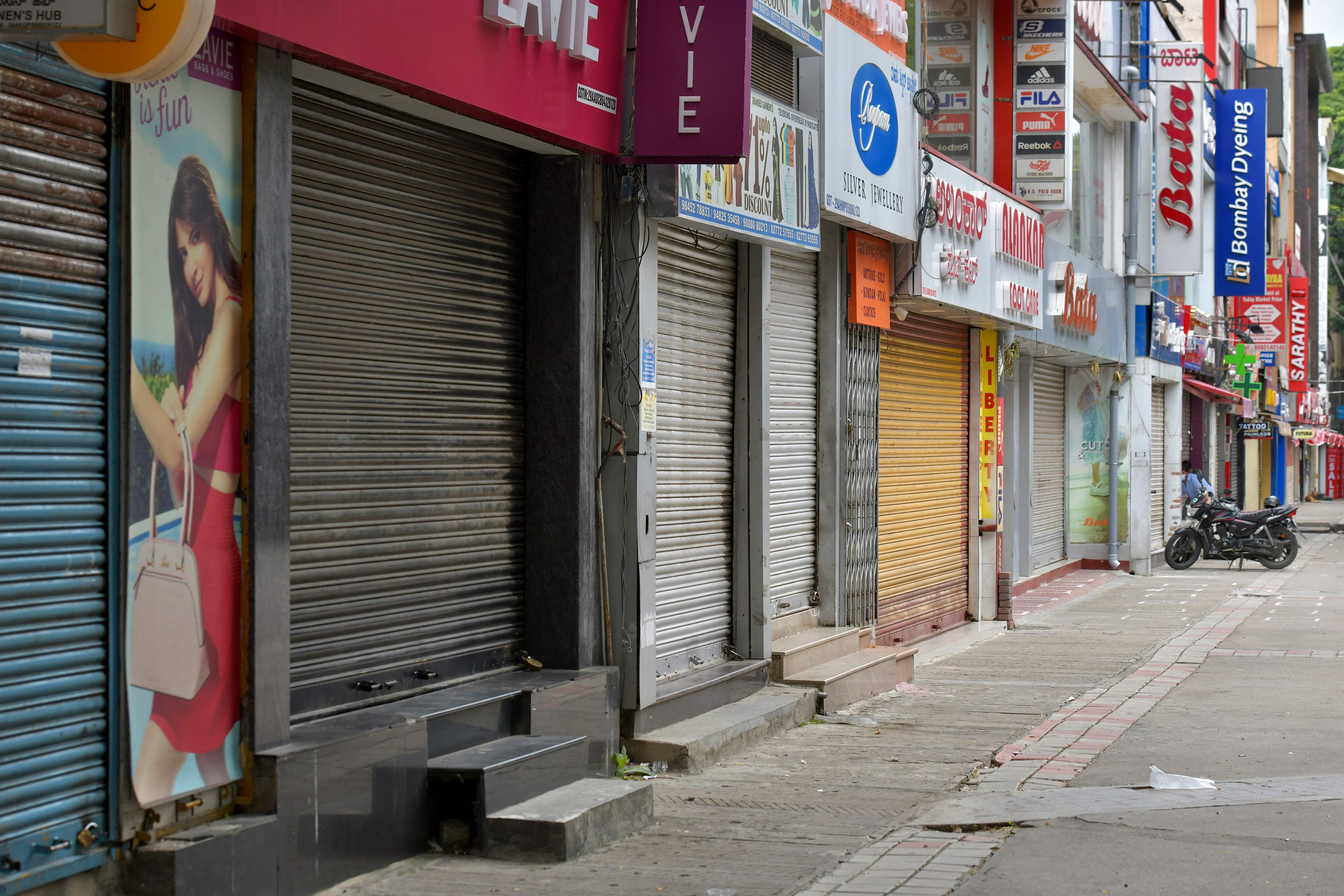 Closed shops are pictured in a commercial area during a week-long lockdown to contain the surge of COVID-19 coronavirus cases, in Bangalore. Credits: AFP Photo