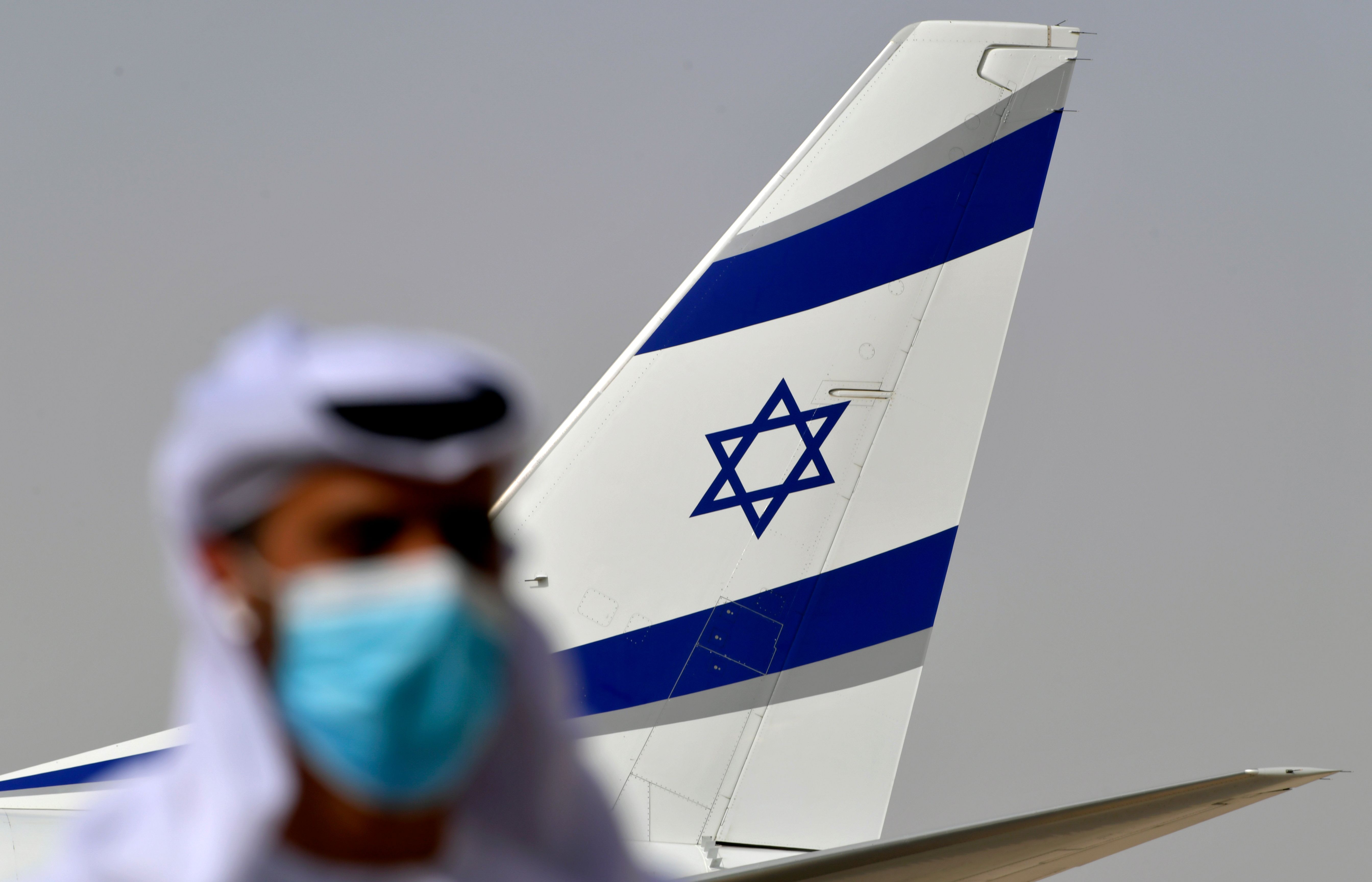 An Emirati official stands near an air-plane of El Al, which carried a US-Israeli delegation to the UAE following a normalisation accord, upon it's arrival at the Abu Dhabi airport in the first-ever commercial flight from Israel to the UAE. Credit: AFP Photo