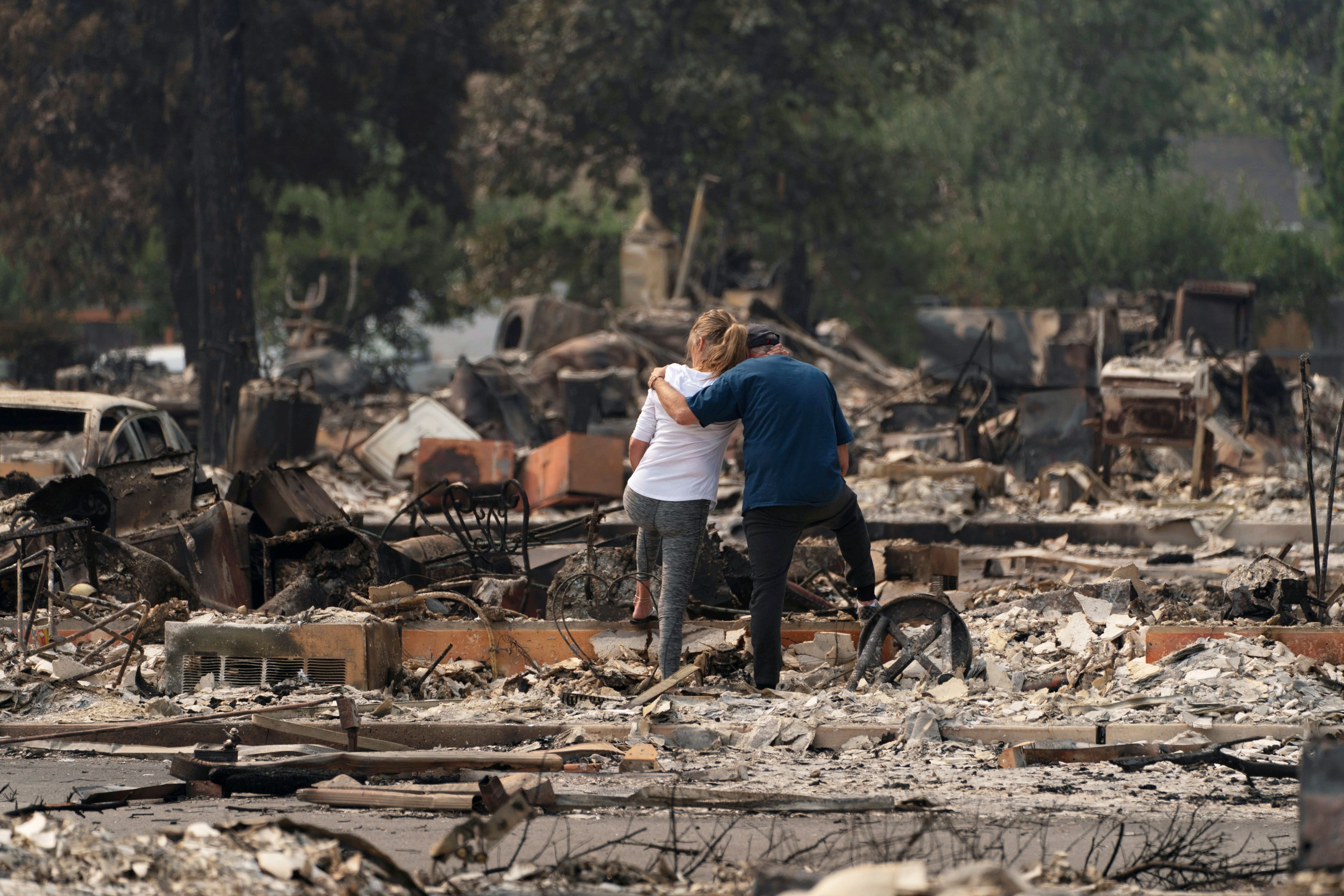 Christina Mitchell embraces her fiance, George Schmoll, amidst the remnants of their apartment after losing items such as her wedding dress and his wedding ring for their December wedding, now postponed, after a wildfire came through the area in Phoenix, Oregon, US. Credit: Reuters