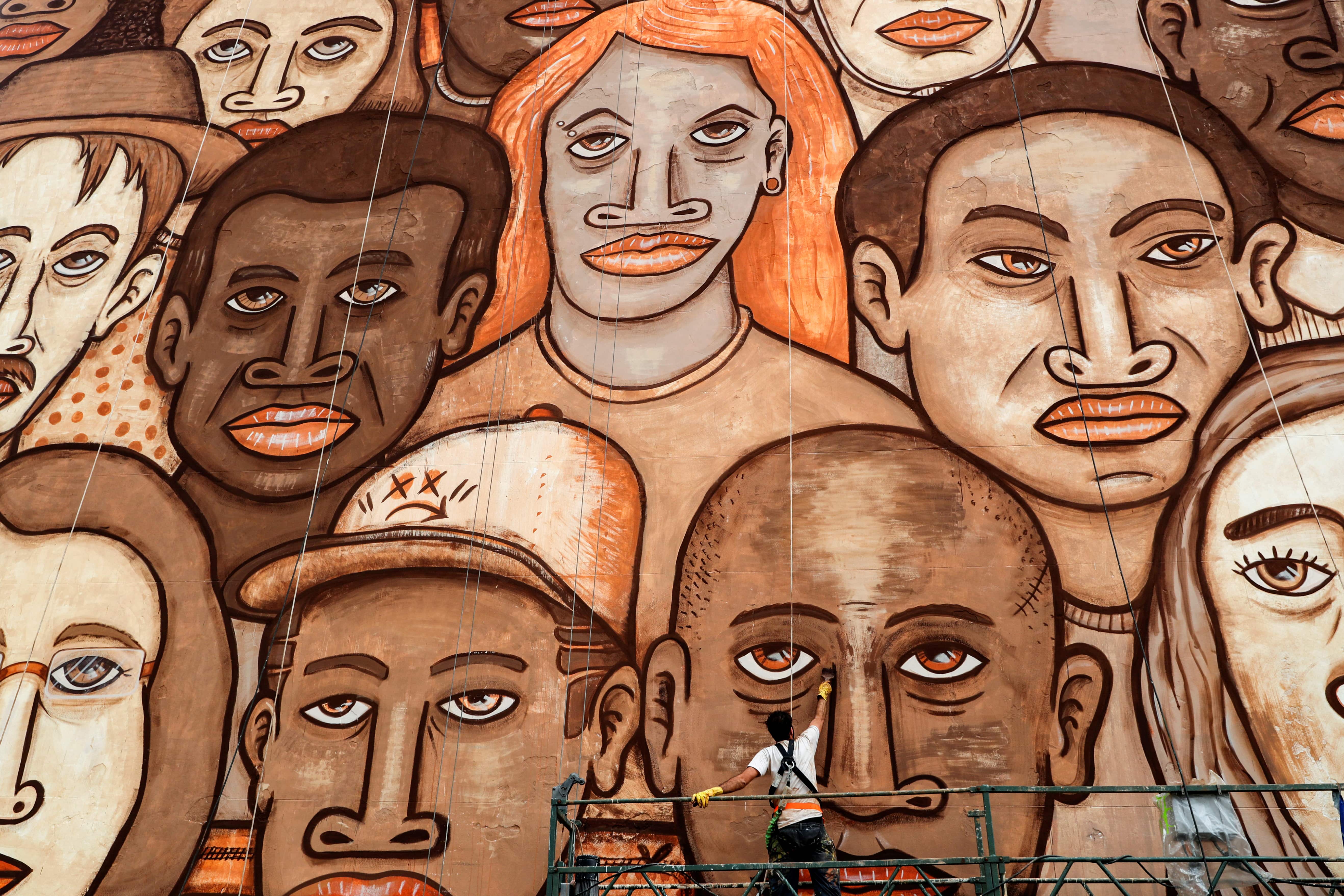Brazilian artist Mundano works on a mural with different colour paints made with dirt and mud brought from the site of the January 25, 2019 collapsed tailing dam owned by Brazilian mining company Vale SA to honour victims of the disaster, in Sao Paulo, Brazil. Credit: Reuters