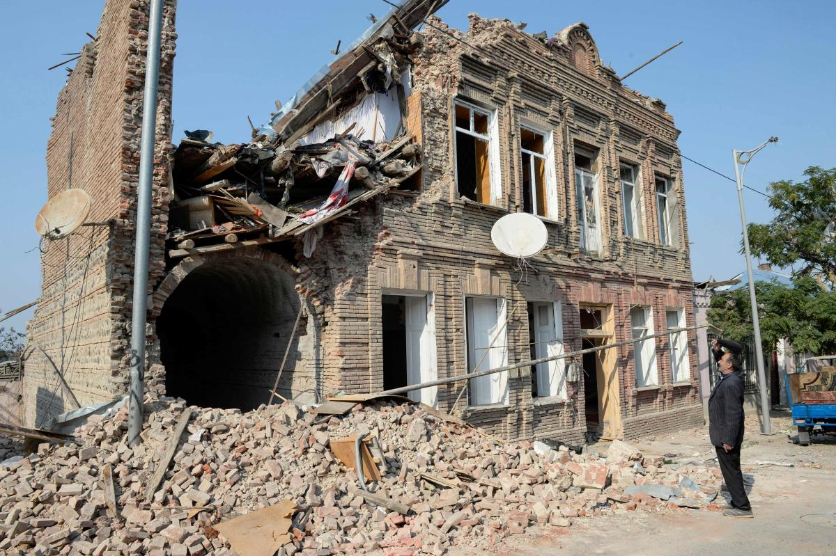 Local man Gambar looks at a residential building damaged by shelling during the ongoing military conflict between Armenia and Azerbaijan over the breakaway region of Nagorno-Karabakh, in the city of Ganja, Azerbaijan. Credit: AFP Photo