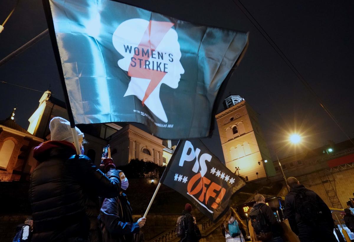 Demonstrators wave flags as they block a street during a protest against the tightening of Poland's already restrictive abortion law in Warsaw. Women in Poland hit the streets nationwide on November 2, the twelfth straight day of mass protests over a court ruling to impose a near-total abortion ban in Poland. Credit: AFP Photo
