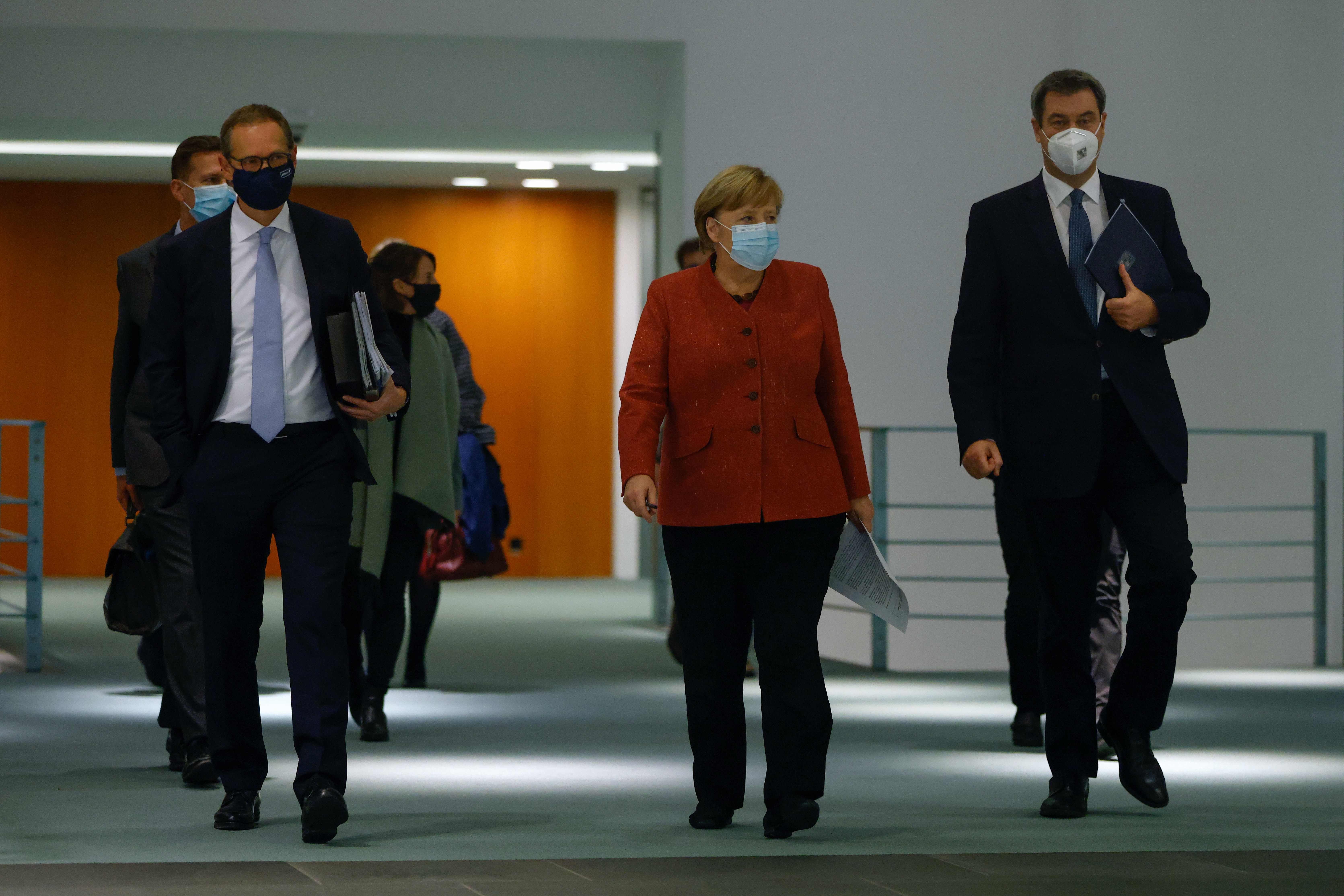Berlin's mayor Michael Mueller, German Chancellor Angela Merkel and Bavaria's State Premier Markus Soeder make there way to a news conference on the coronavirus following video consultations with the premiers of Germany's 16 federal states at Chancellery in Berlin. Credit: AFP Photo