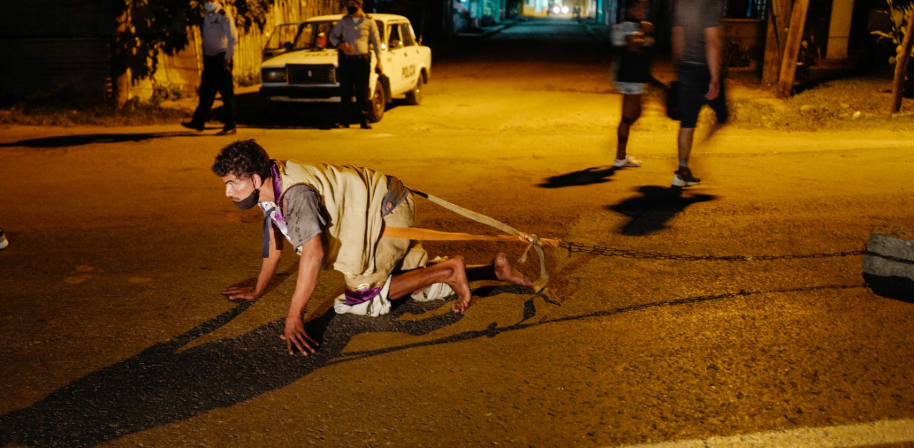A pilgrim drags stones during the Saint Lazarus procession in El Rincon, Havana province, Cuba. Credit: AFP