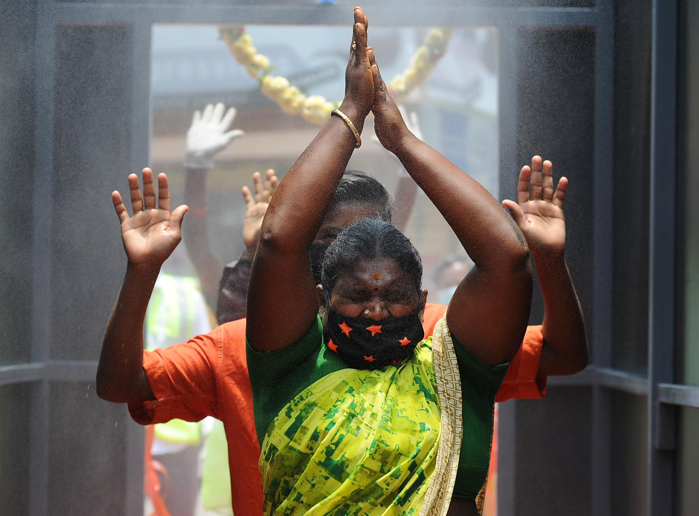Disinfectants at the end of the tunnel | People pass through a sanitisation tunnel to prevent the spread of coronavirus in Bengaluru before the Supreme Court and several other agencies deemed them inefficient in actually preventing the spread of the virus. Credit: DH Photo/ Pushkar V