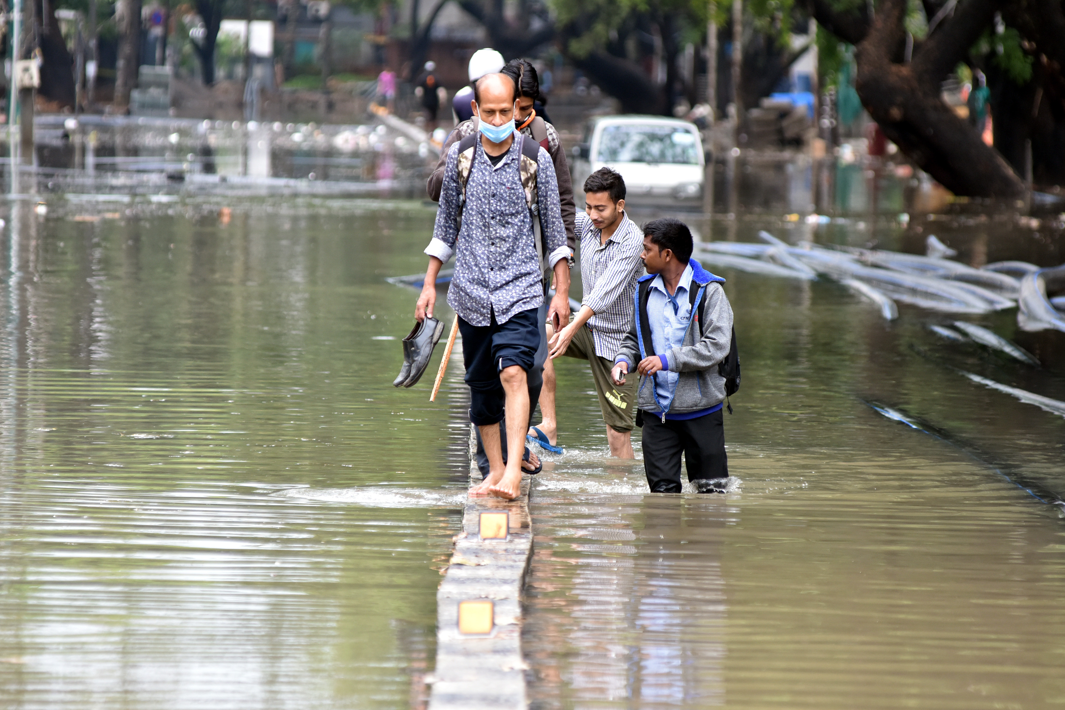 Double Whammy with heavy rains and Covid-19 | For the third consecutive year,several parts of Karnataka were battered by torrential rains and floods. People struggle to cross the road due to stagnant water after heavy rain in Koramangala. Credit: DH Photo/ S K Dinesh
