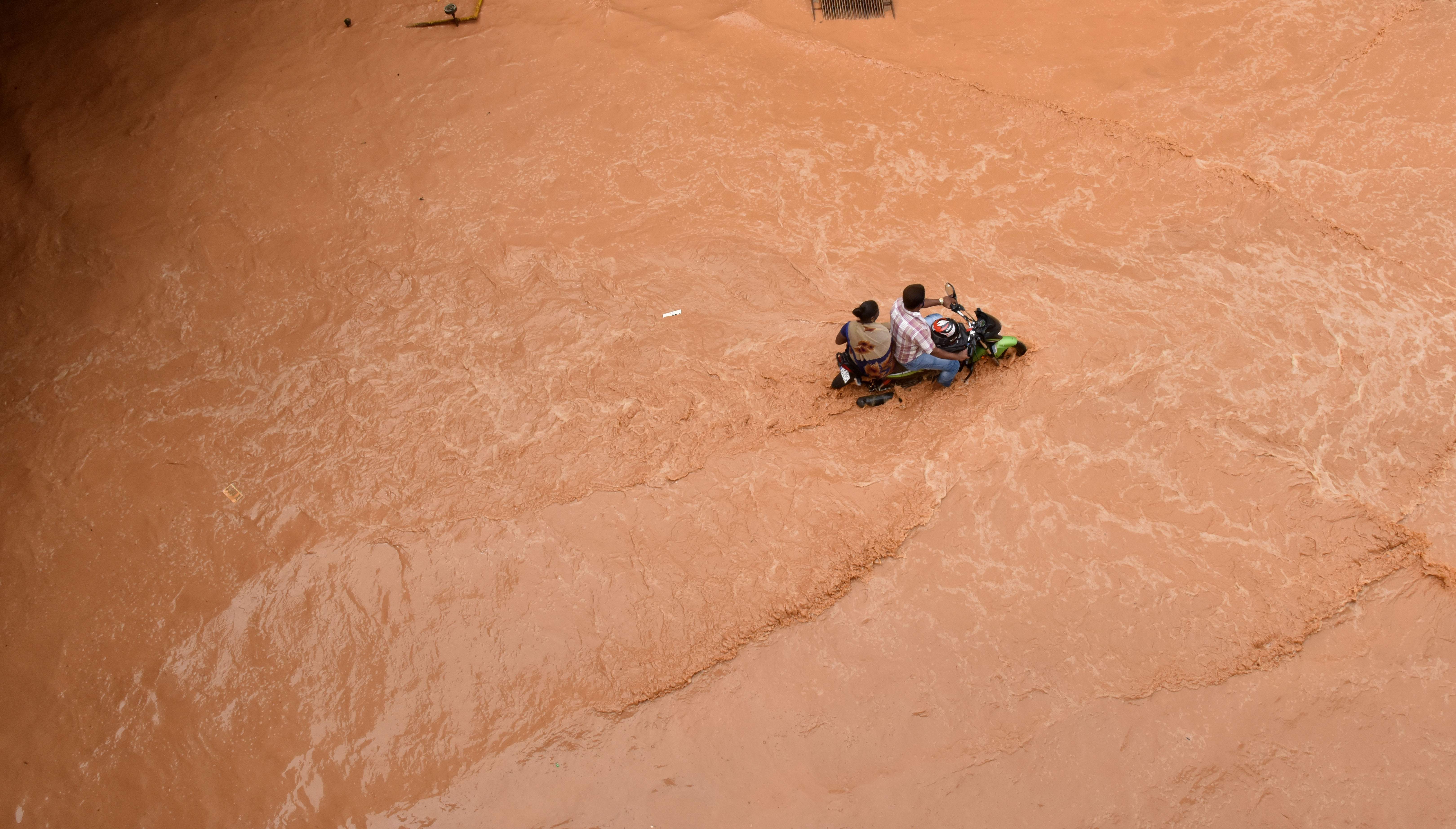Ravaging virus, a deluge | A man rides a motorcycle on a water logged railway underpass in Bengaluru. Battered by torrential rains and floods in August and later in September and mid-October, this was the first time that Karnataka witnessed faced floods in Krishna and Bhima basins in a single year. The government estimated the damage from floods and landslides at Rs 15,410 crore. Credit: DH Photo/ Janardhan BK