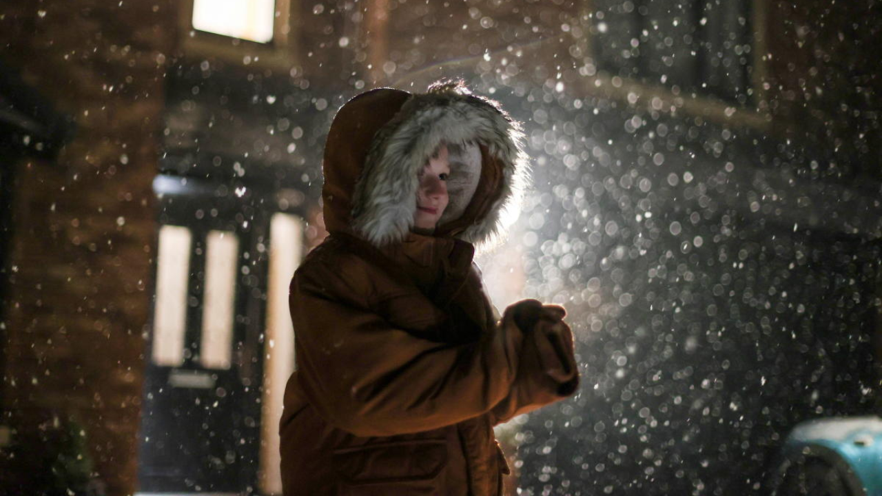 Zac applauds in the snow during the Clap for Heroes campaign, outside his house in Keele, Staffordshire, Britain. Credit: Reuters Photo