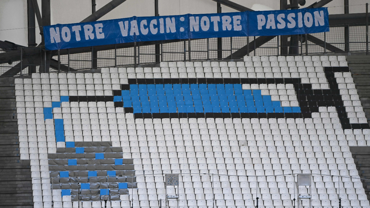 A picture shows seats fitted with coloured sheets to depict a syringe and the coronavirus and a banner reading
