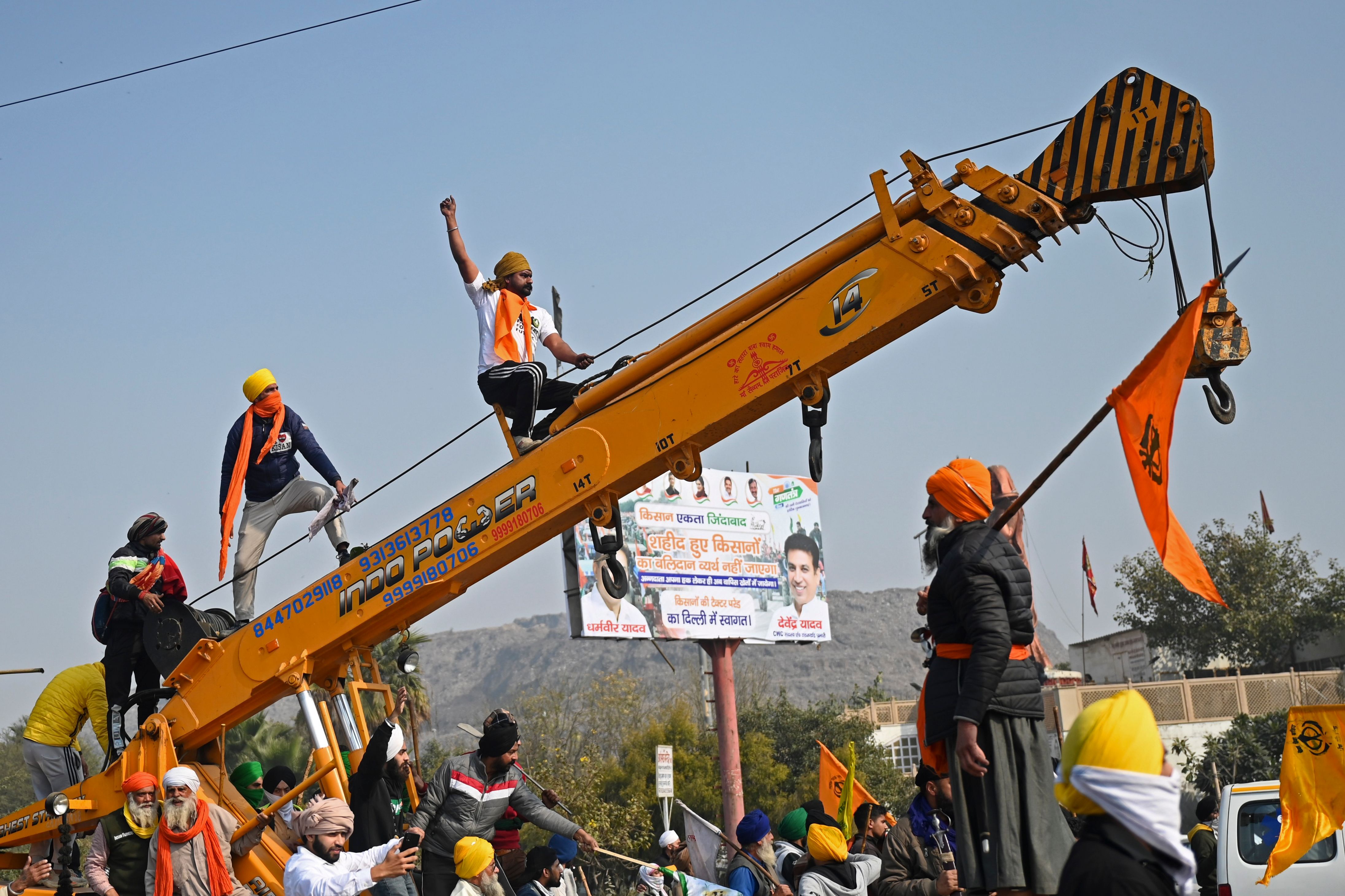 Wielding sticks and clubs and holding the tricolour and union flags, tens of thousands of farmers atop tractors broke barriers, clashed with police and entered the city from various points to lay siege to the Red Fort and climb the flagpole there on Republic Day. Credit: AFP