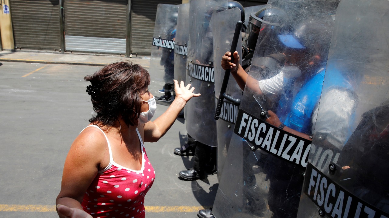 A street vendor argues with police officers over new lockdown measure that include instructions to work from home, the closure of all non-essential shops by the government, due to the Covid-19 outbreak in Lima, Peru. Credit: Reuters Photo